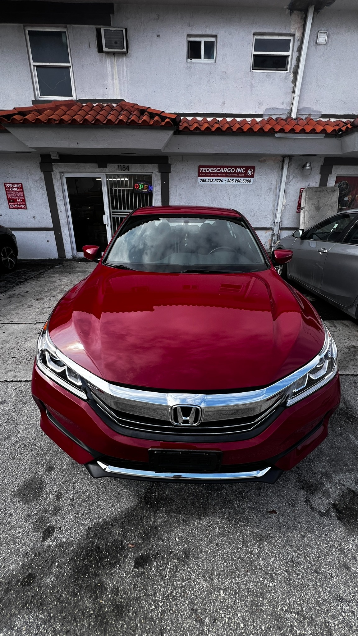 Vista frontal de un Honda Accord rojo inspeccionado antes del envío