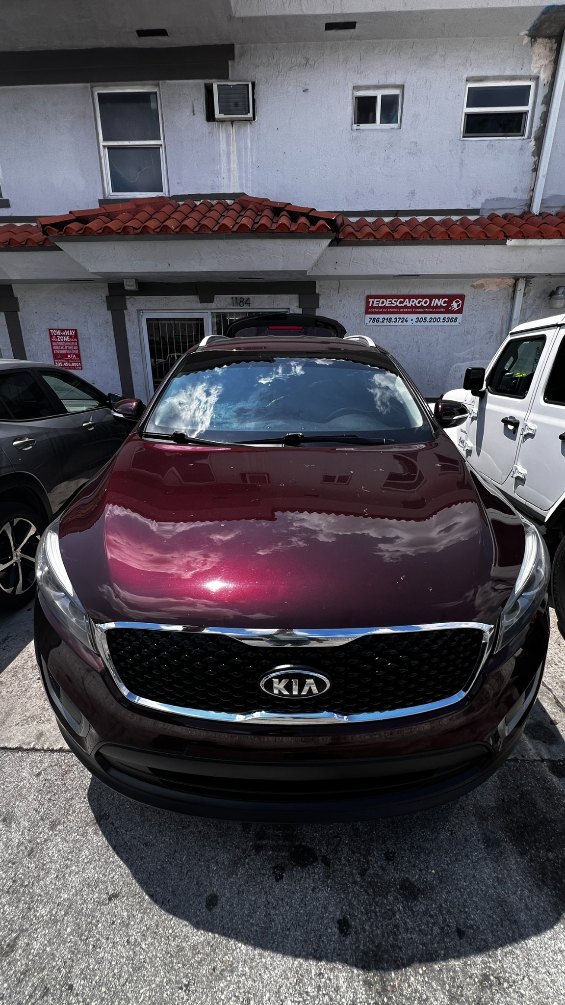 Vista frontal de un Kia Sorento color borgoña preparado para envío